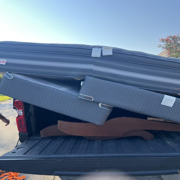 Colchones y cabecera de madera cargados en una camioneta
